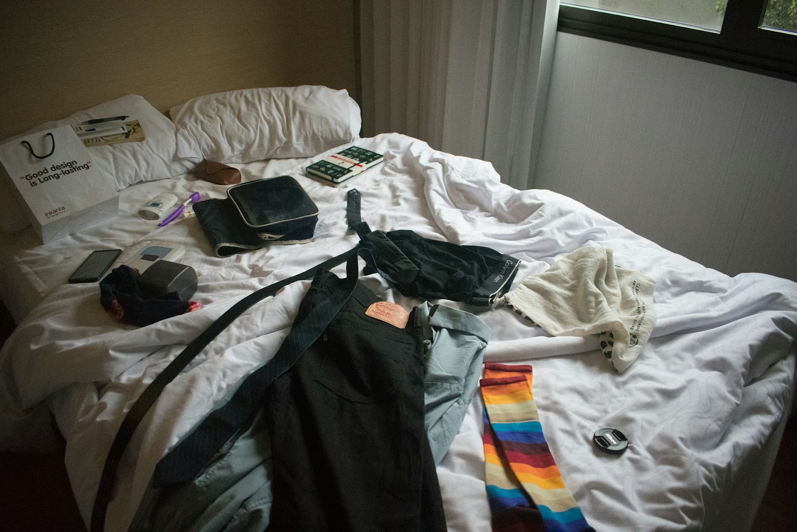 A man's clothes placed on the bed.