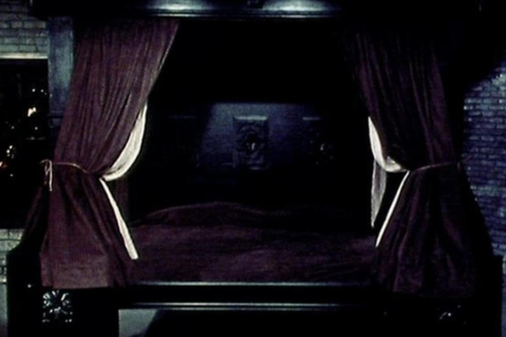 Old-style brown bed with curtains