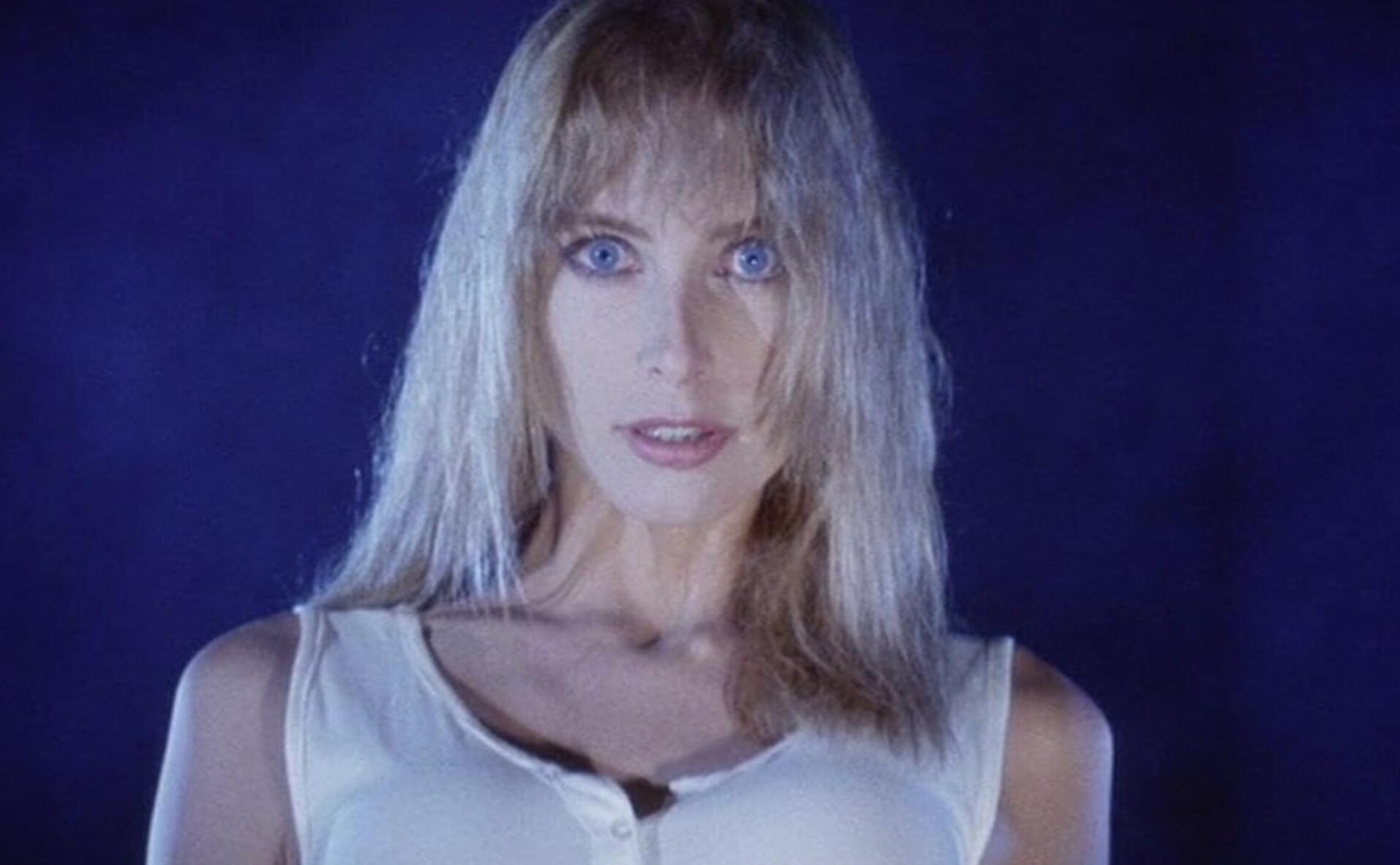 Blonde lady in white with bright blue eyes