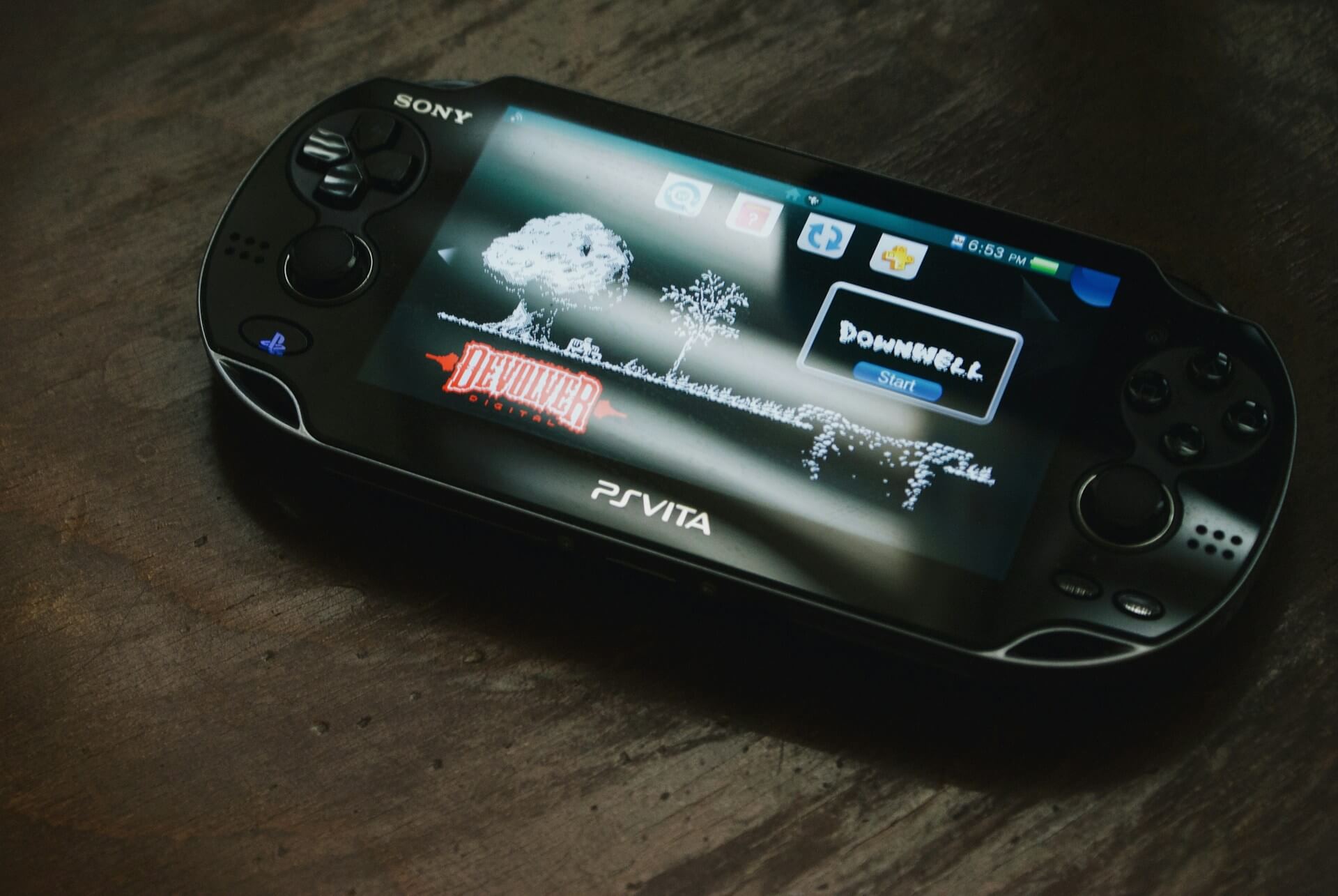 Black PlayStation Vita on a wooden surface