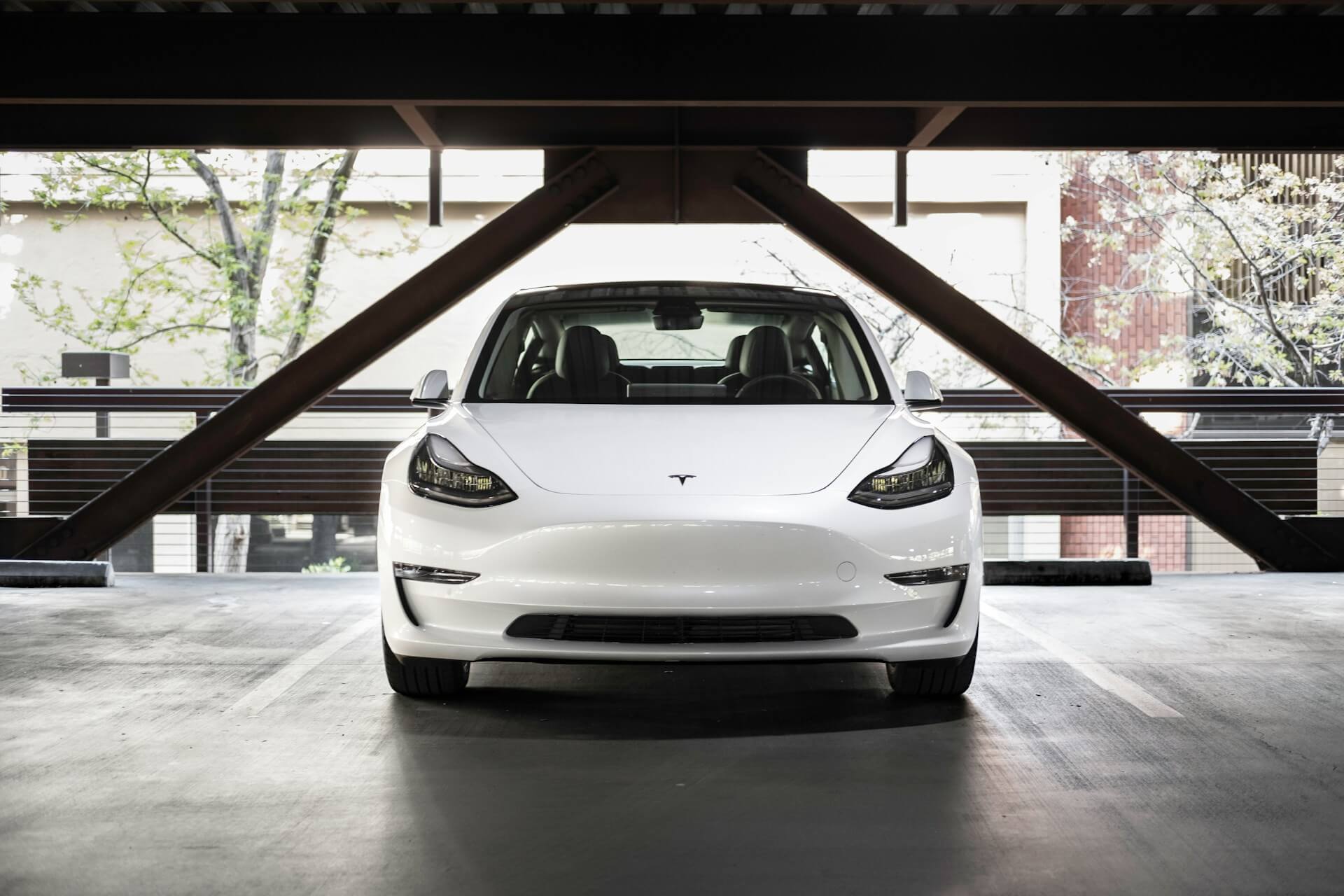 White Tesla Model 3 sits in a parking garage