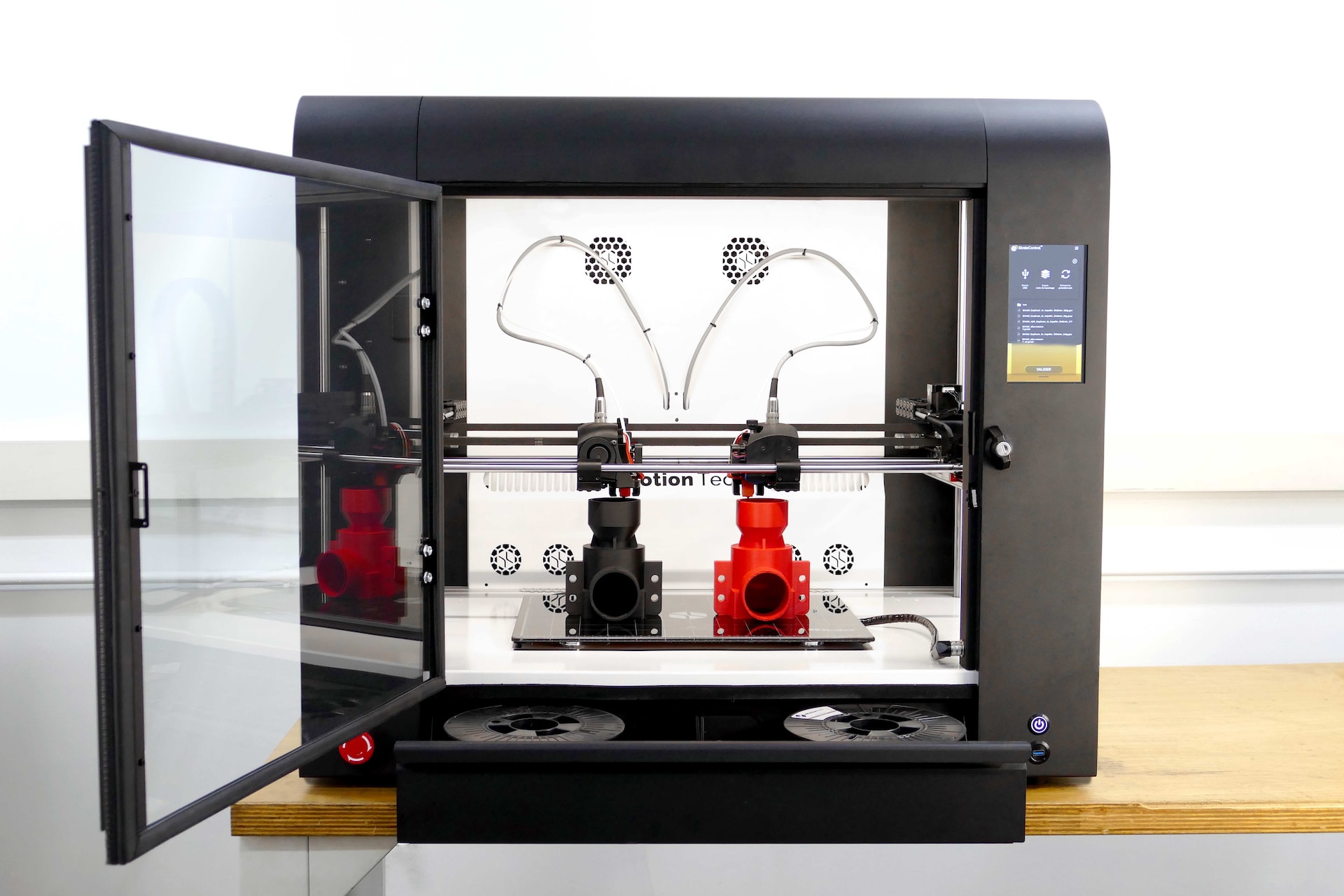 A 3D printer with an open glass door.