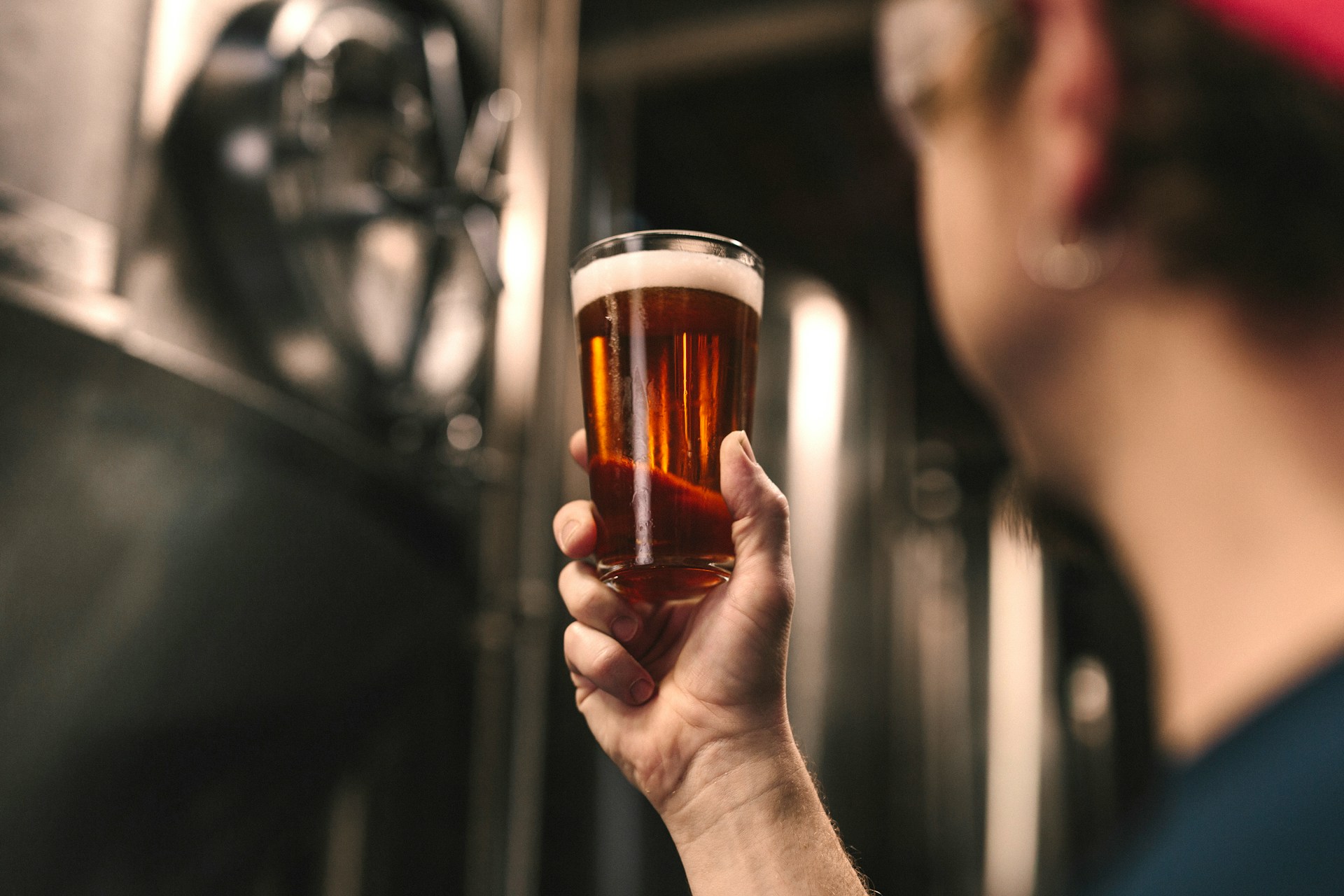a man examining a fresh glass of beer