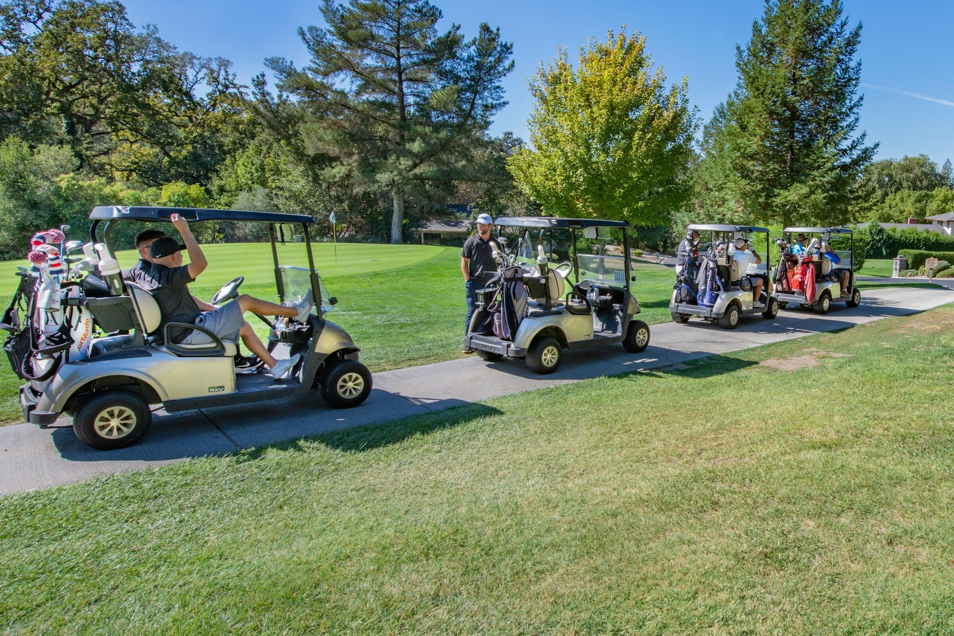 Group of people in golf carts.