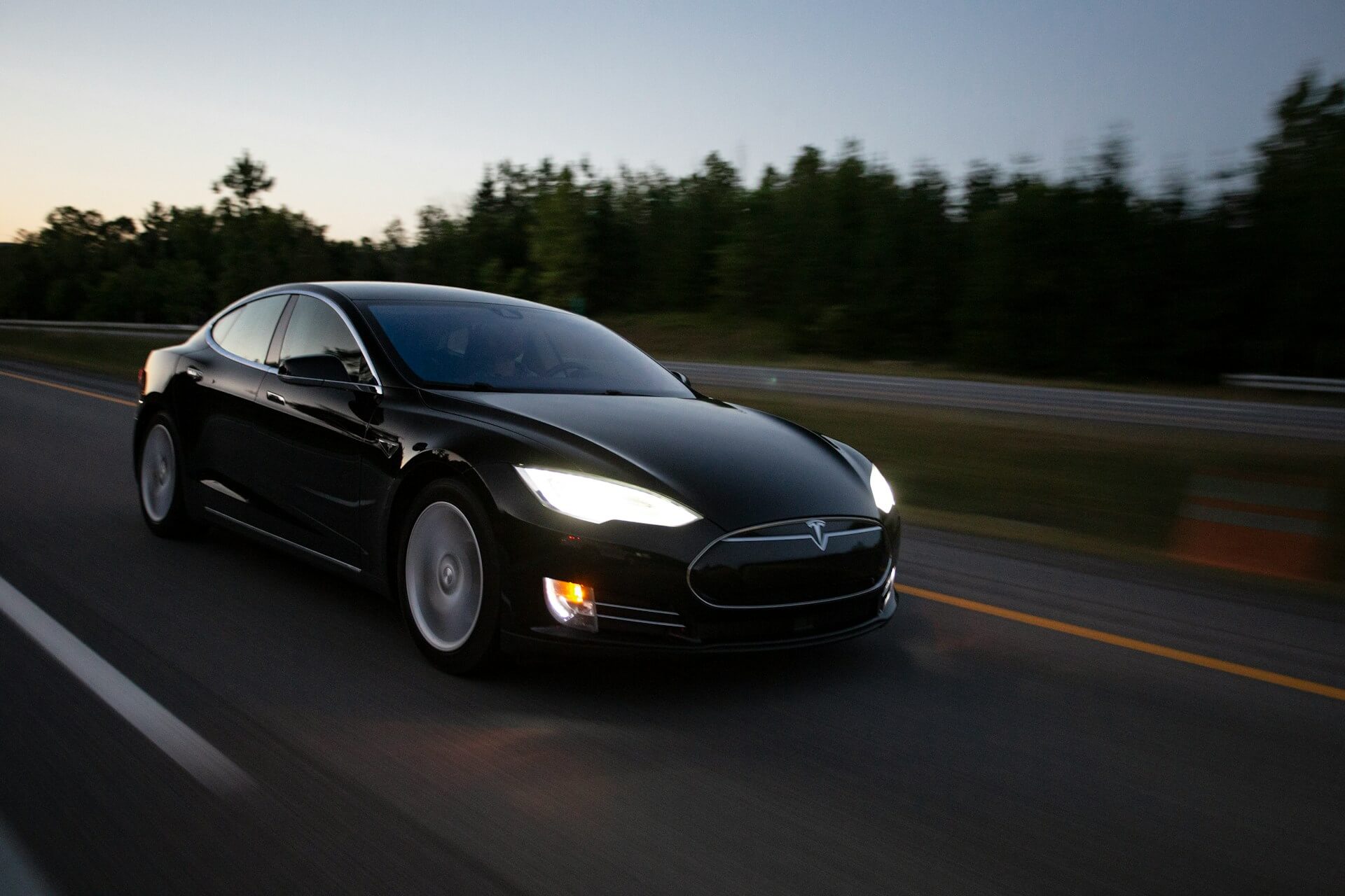 Black Tesla Model S driving on the highway.