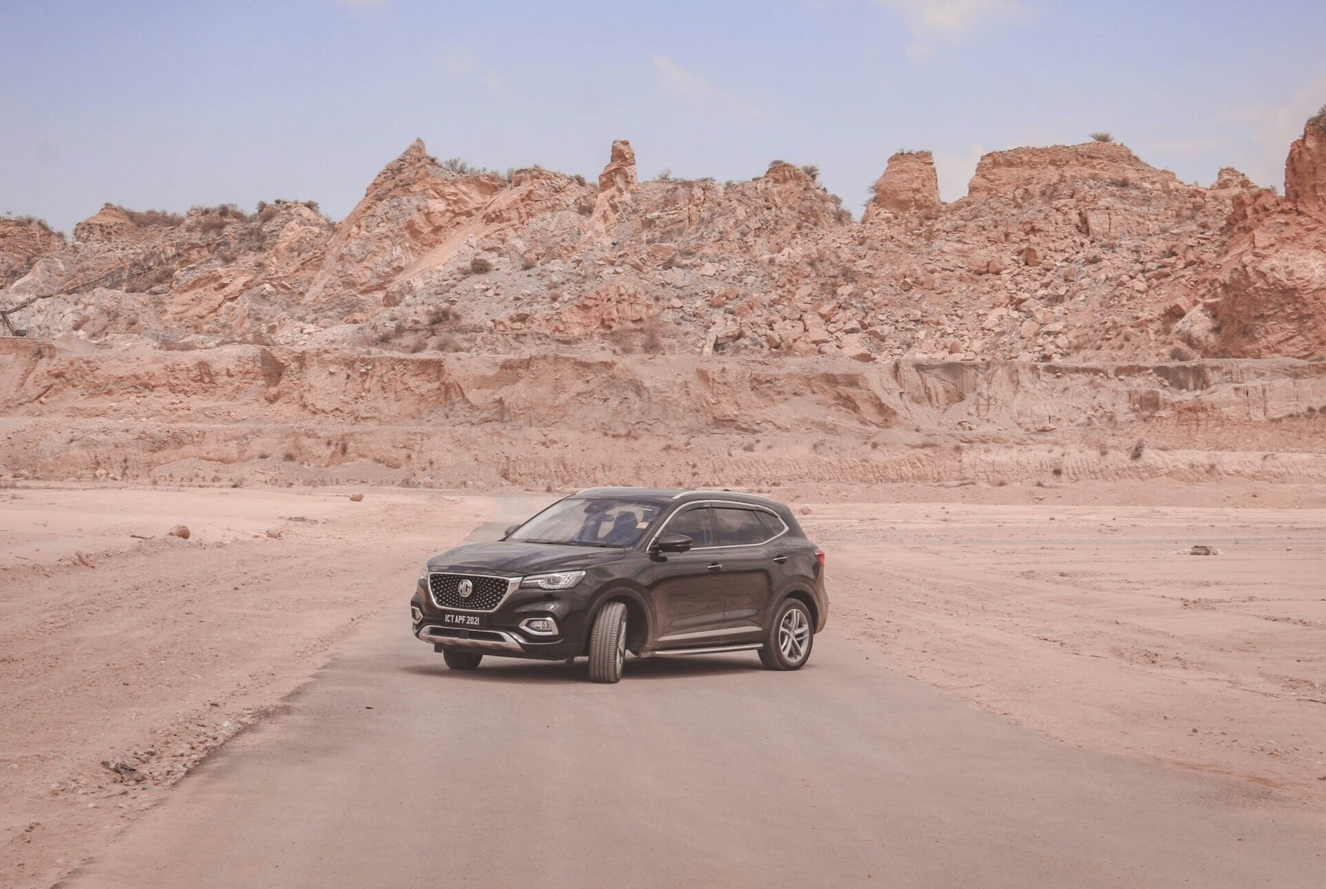 black suv in the dessert in front of mountains