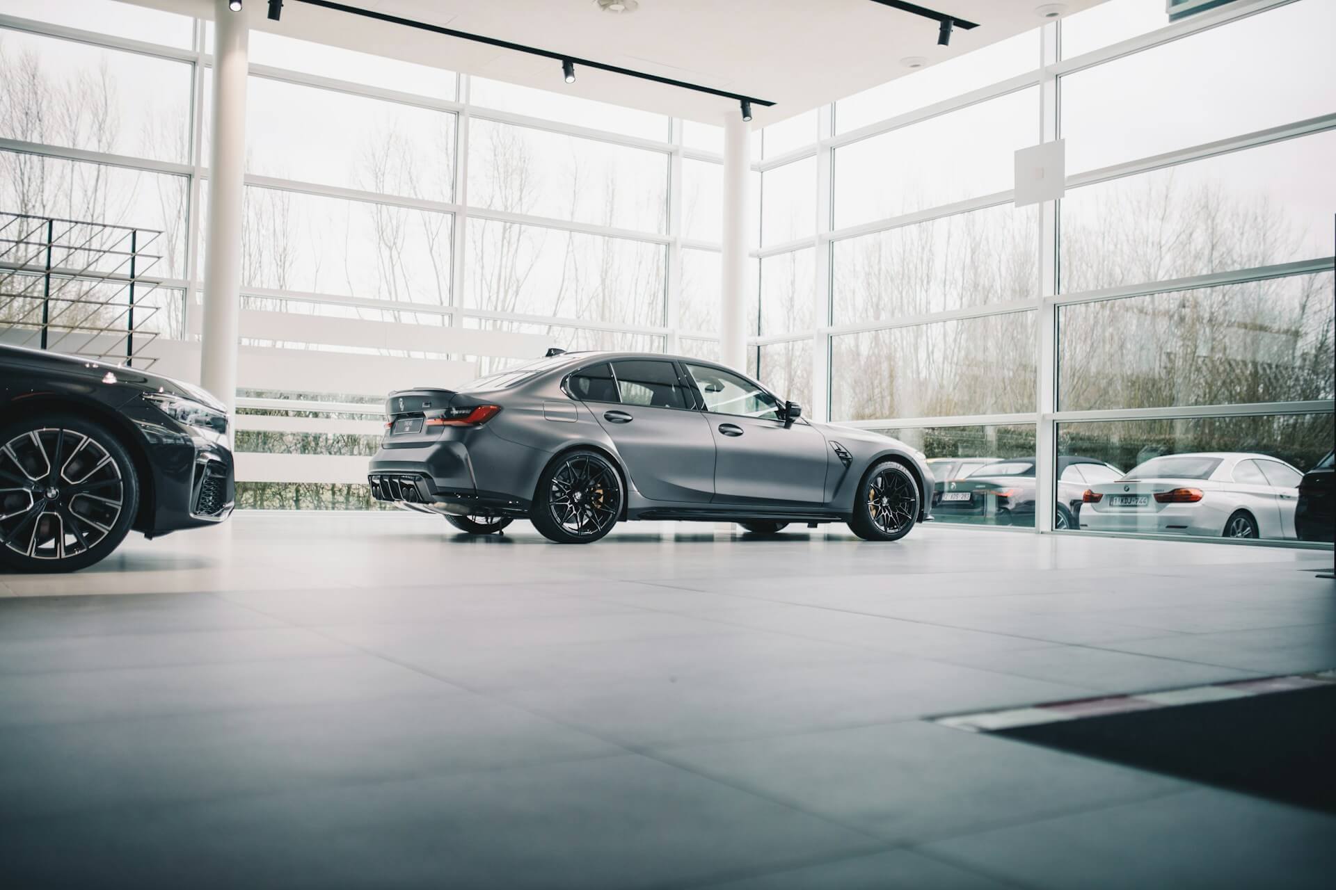 A gray sedan parked on a dealership floor