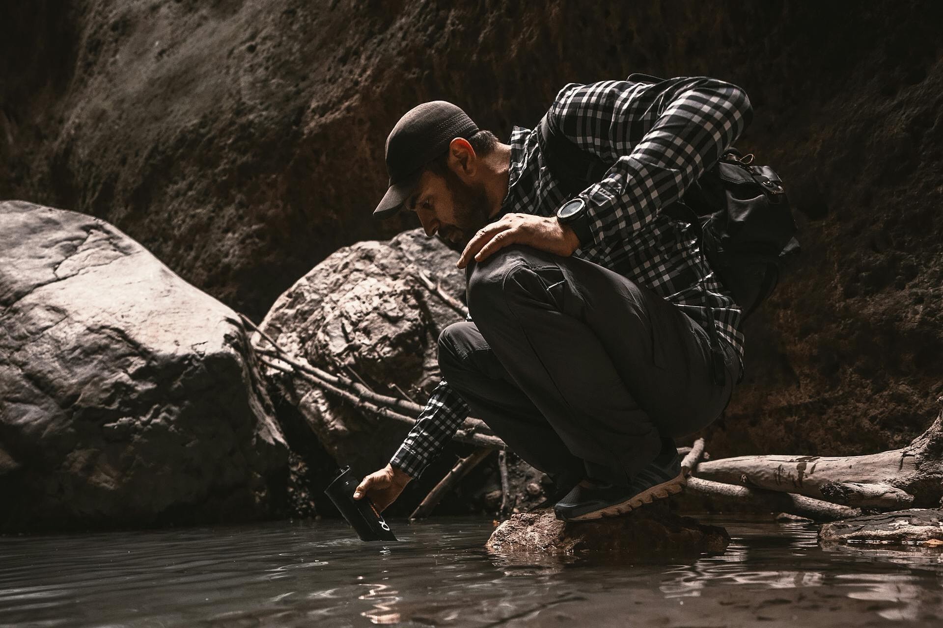 a man collecting water from a pond