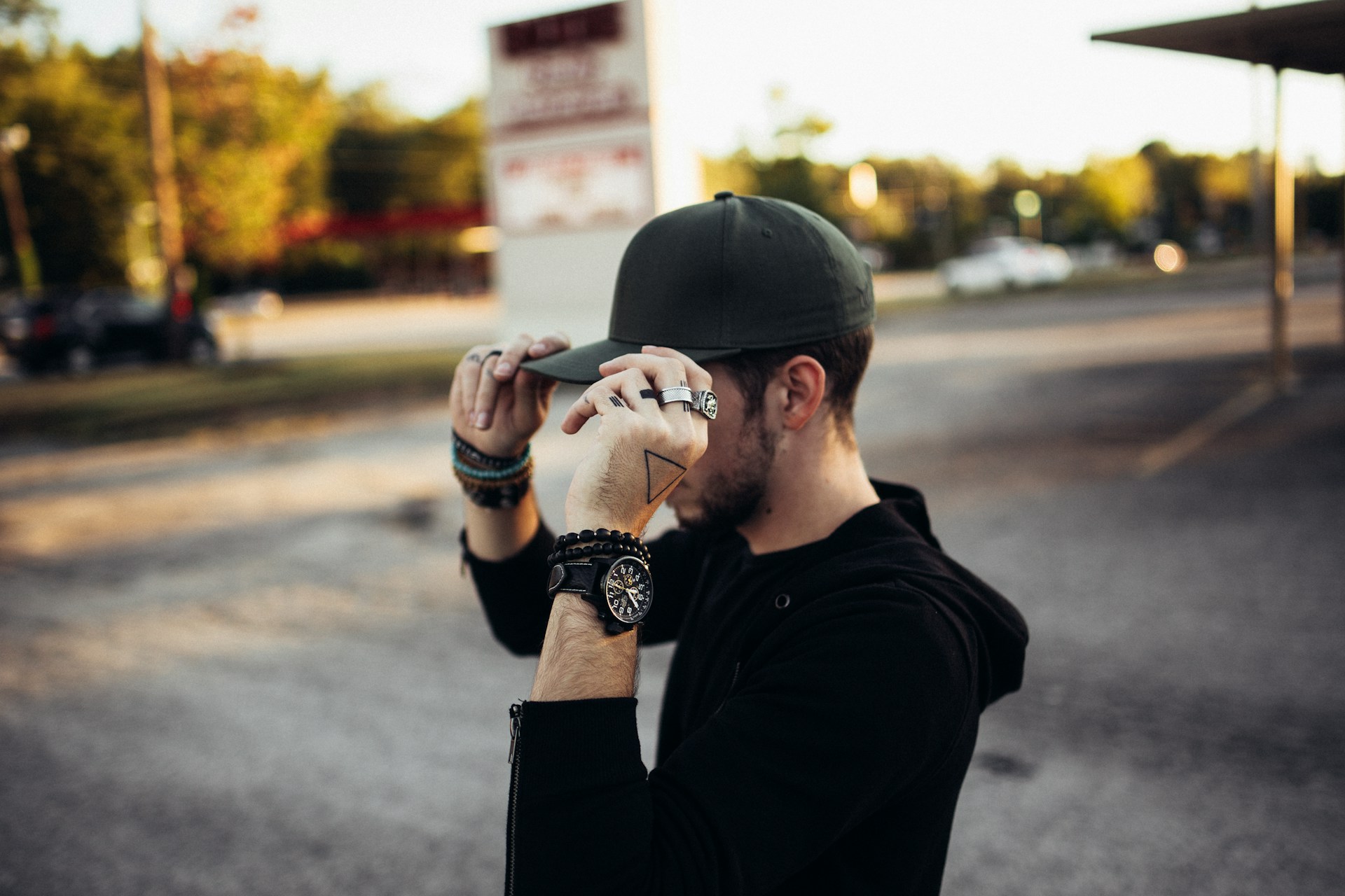 a man hiding a haircut with a hat and jewelry