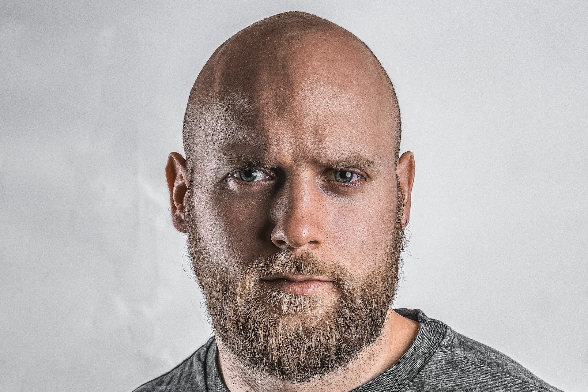 A man with a nearly-full shaved head