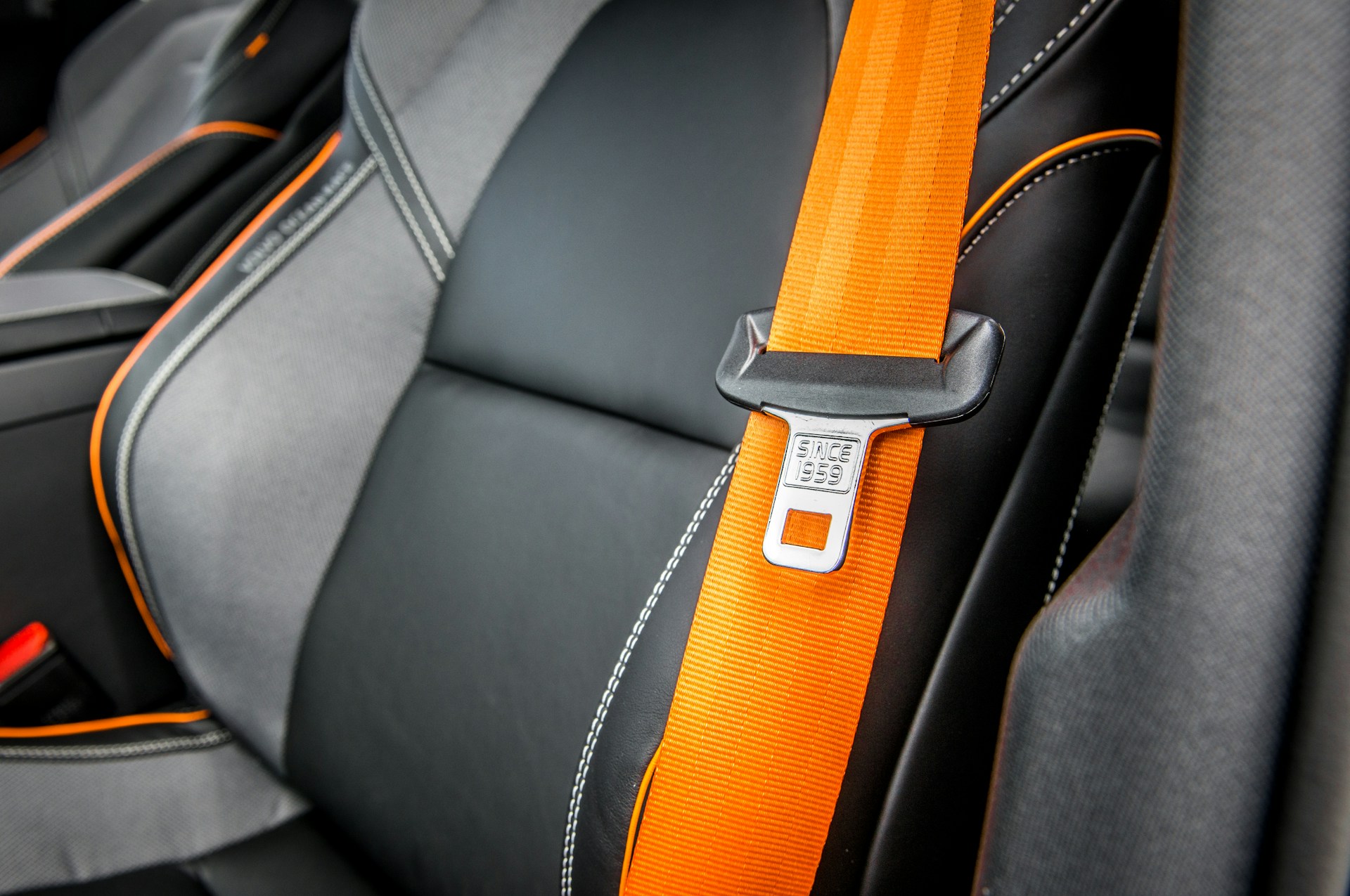 orange seatbelt on a black seat