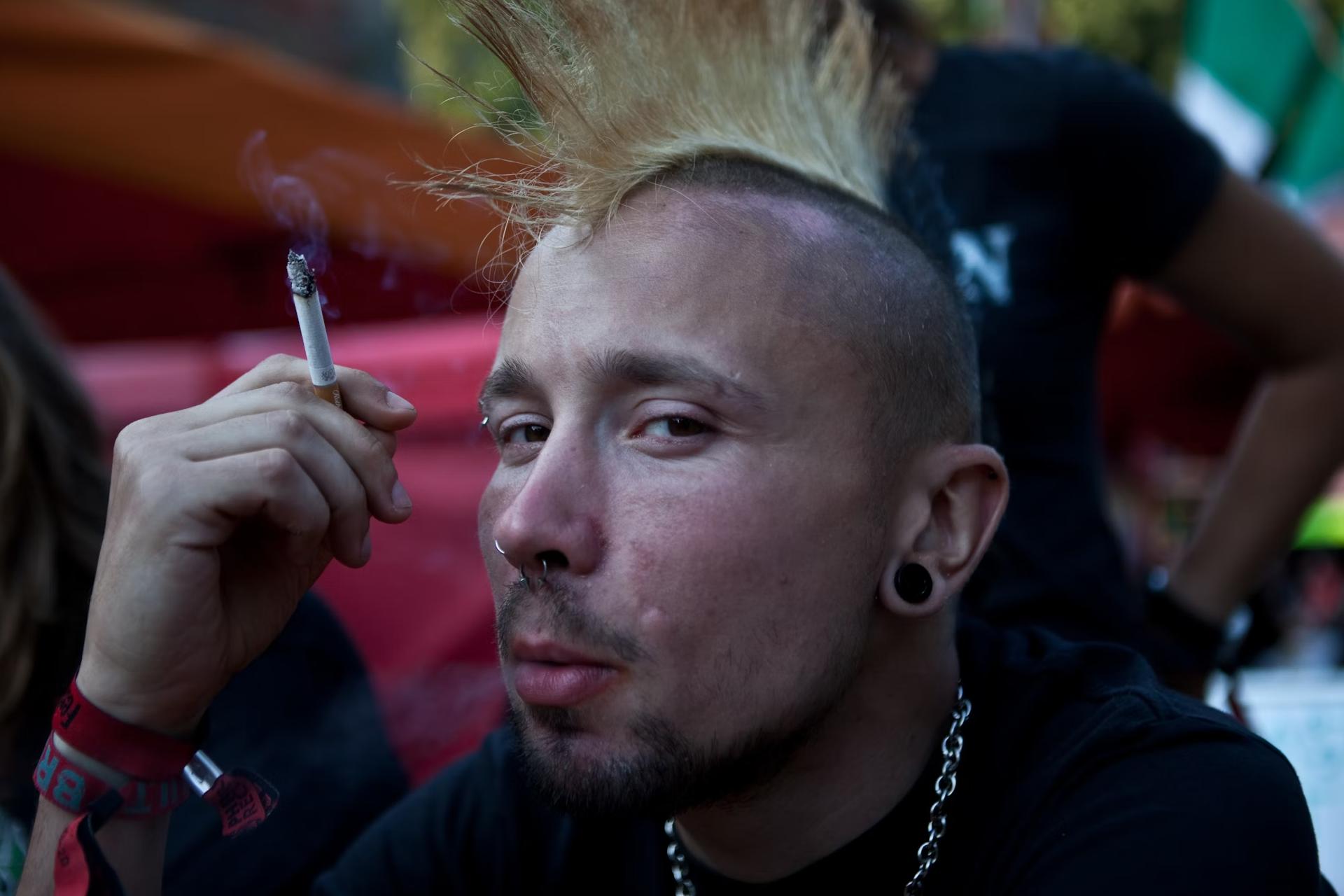 punk man wearing chain and smoking