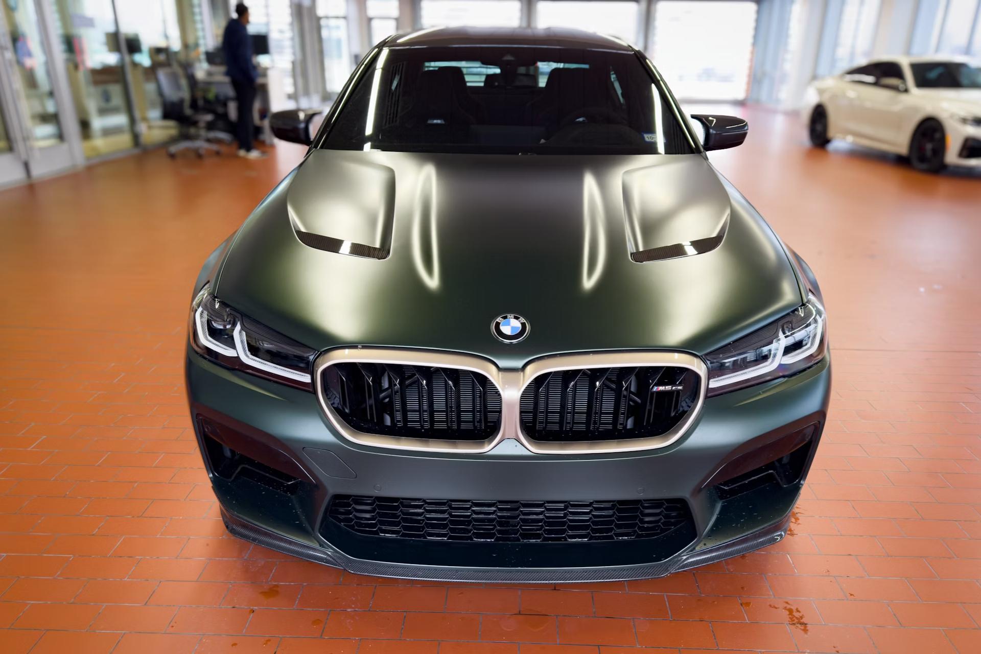 Green BMW car in orange floor with glass doors behind