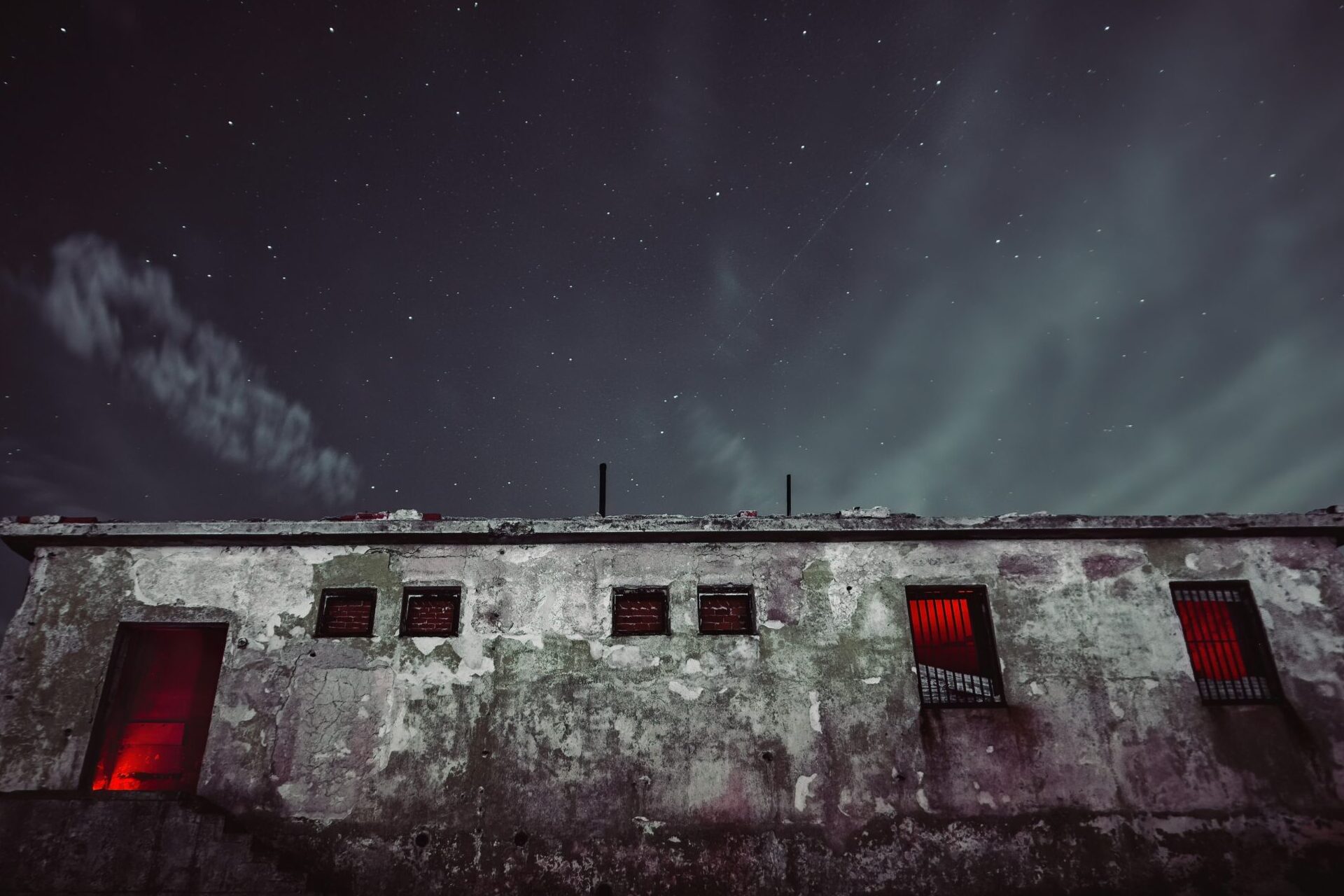 abandoned building with red lights and a clear sky.