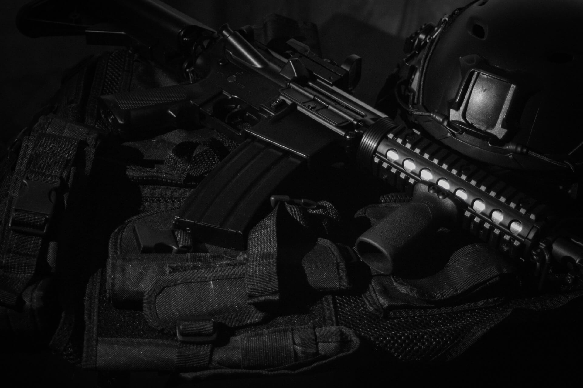 A black assault rifle replica on black textile.