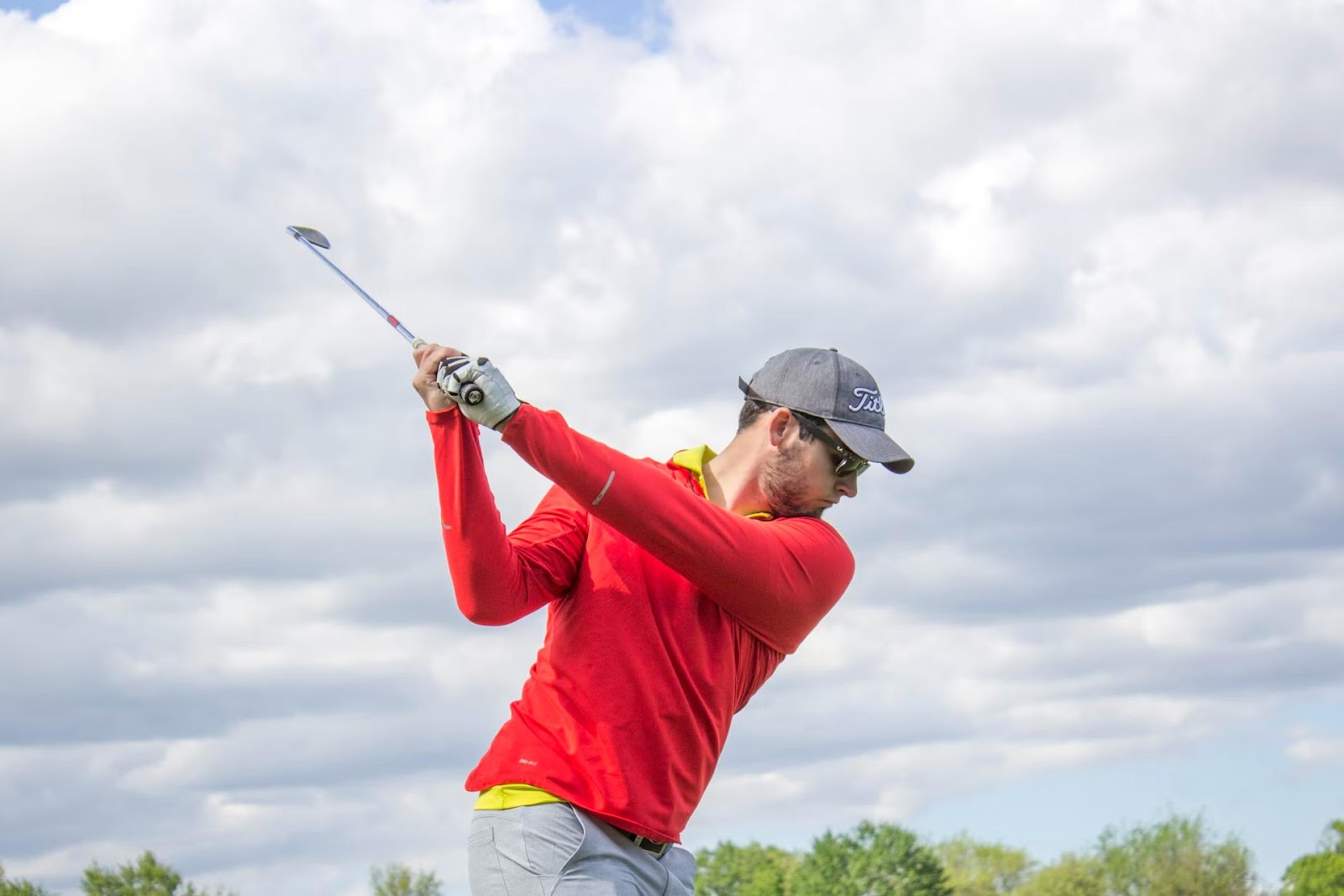 golfer in red top on backswing