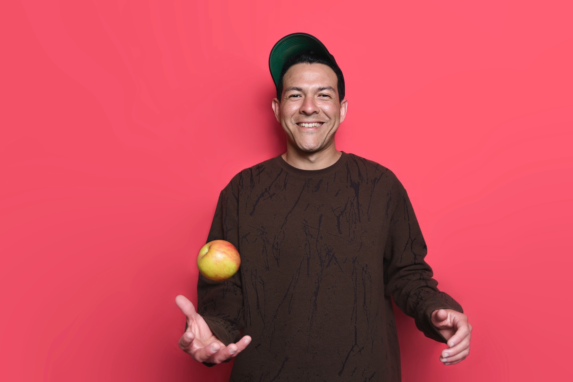 how to juggle - a man juggling an apple