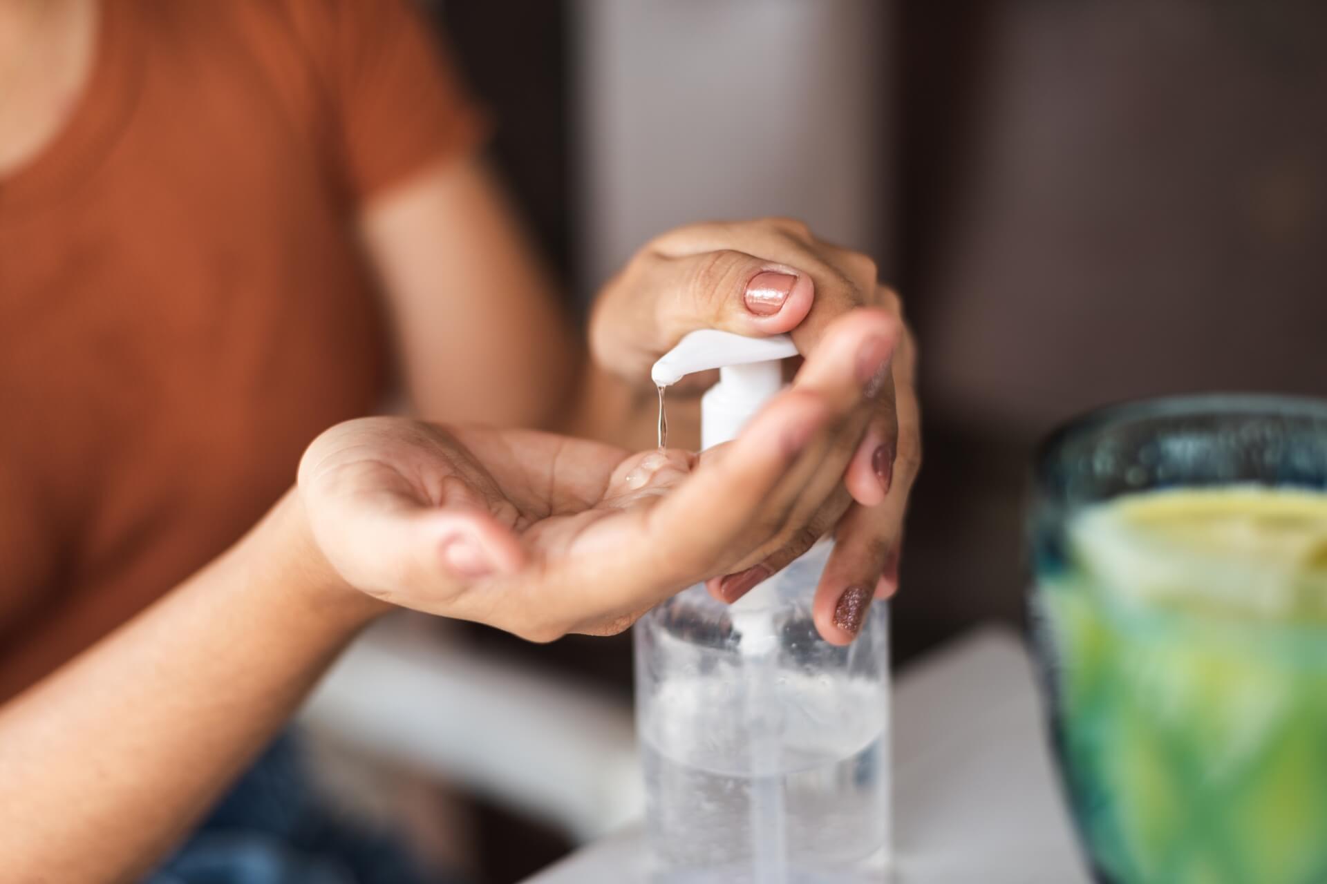 Woman pressing on a bottle of hand soap.
