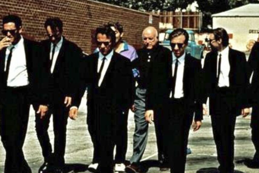 a group of men in black walking with heads down