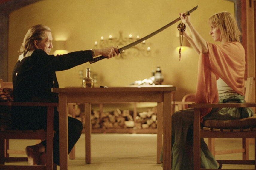 man in black with sword being held by woman