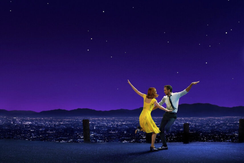 man dancing with woman in yellow dress against purple sky