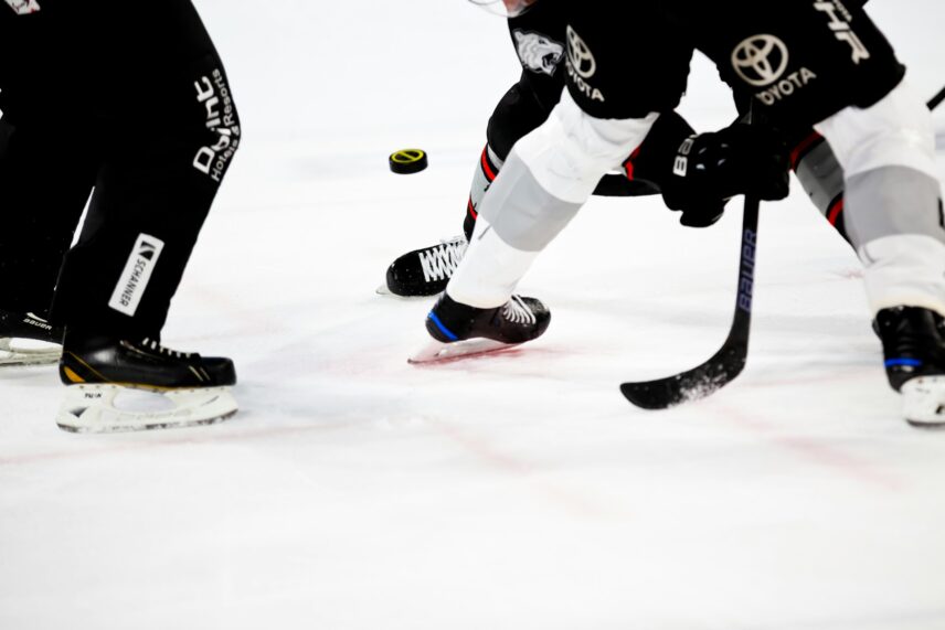 Action shot of hockey players and referee's legs on the ice