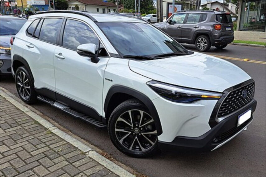 white car on road next to sidewalk