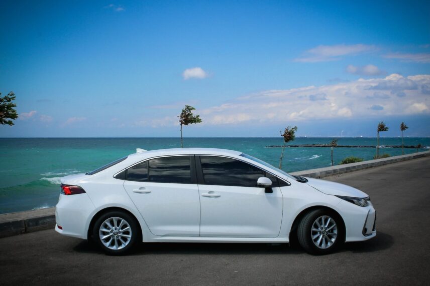 White Toyota Corolla parked by the coast