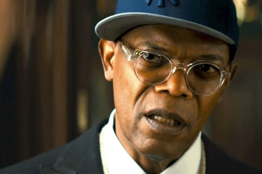 man wearing glasses in black top with blue cap