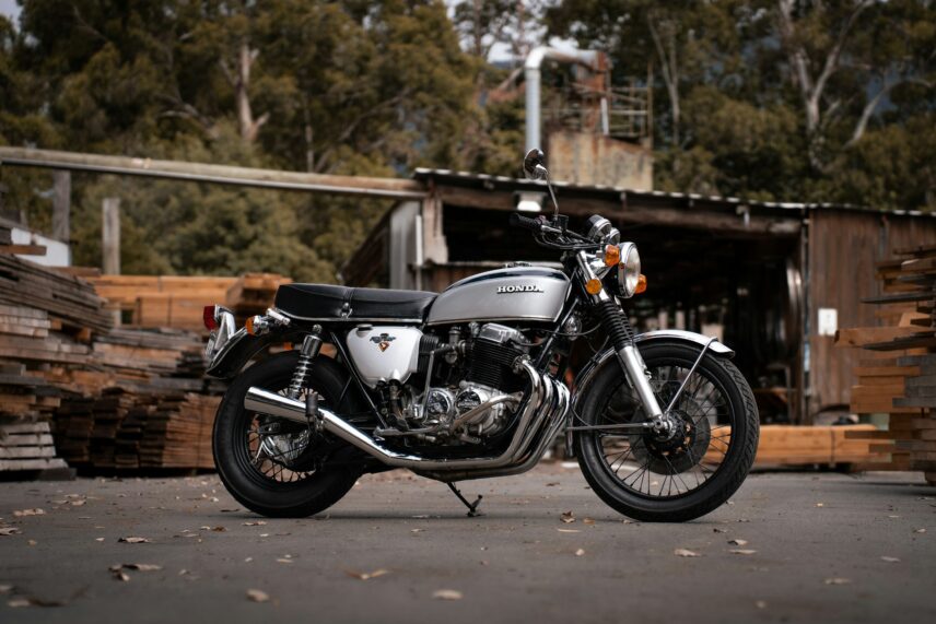 Vintage Honda CB750, among the best vintage motorcycles, parked in front of wood piles
