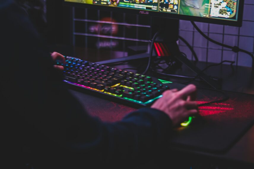 a man’s hands playing a PC game