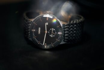 Classic watch against dark background with lens flare