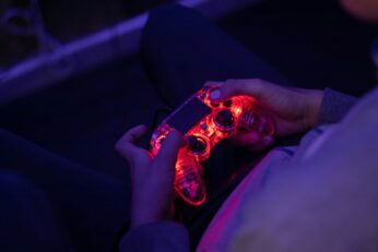 a person holding a video game controller in their hand, playing a fake video game