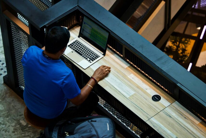 a man in front of a laptop using Microsoft Excel