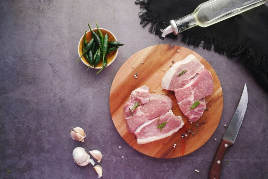 Raw steak cuts on a cutting board with seasoning
