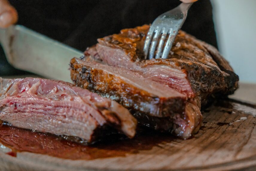 Someone cutting red meat, which is often used for protein maxxing