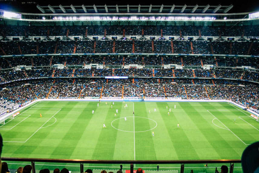 Full stadium with people watching green field of players
