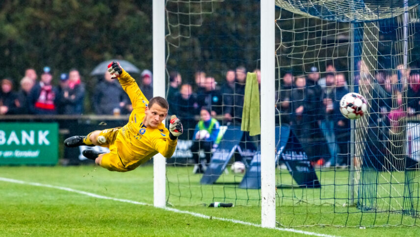 Man in yellow diving across goal