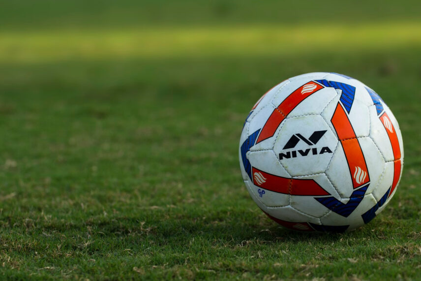 red, blue and white soccer ball on grass.