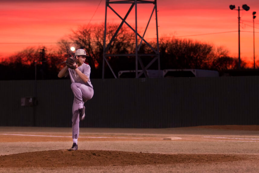 lady pitcher posing on field at sunset
