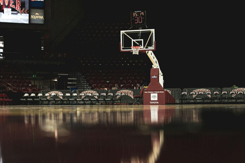 White and red basketball hoop mounted in an indoor gymnasium