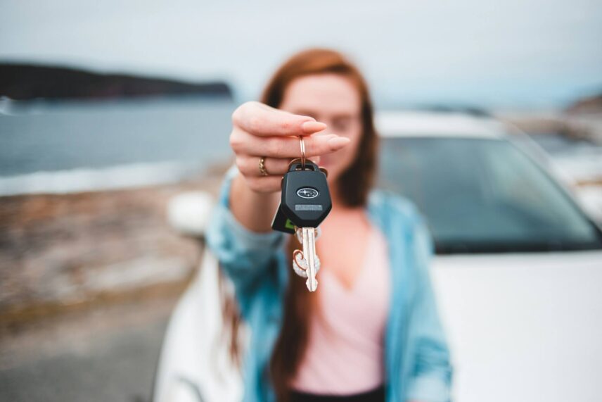 Woman in front of a car and holding a keychain