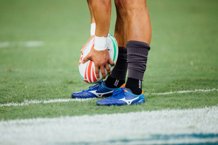 A rugby player about to kick the ball.