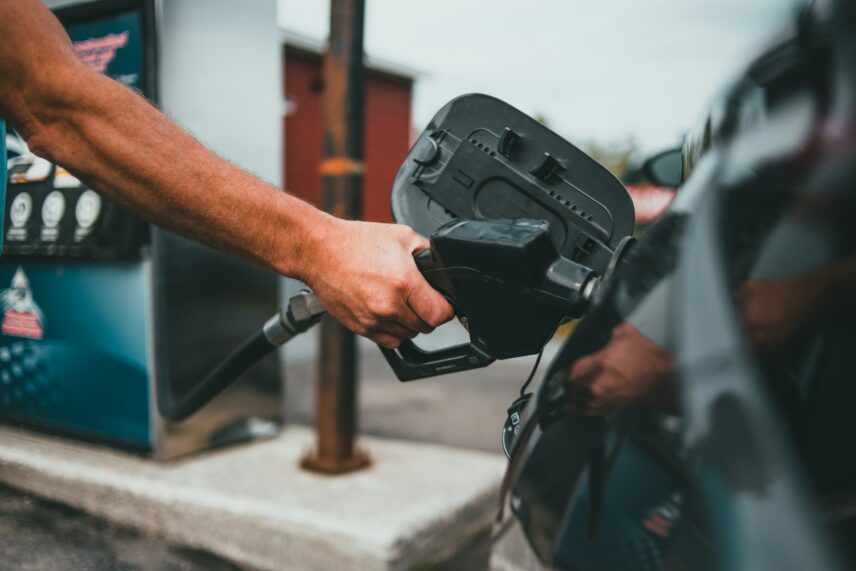 A person's arm pumping gas into their vehicle