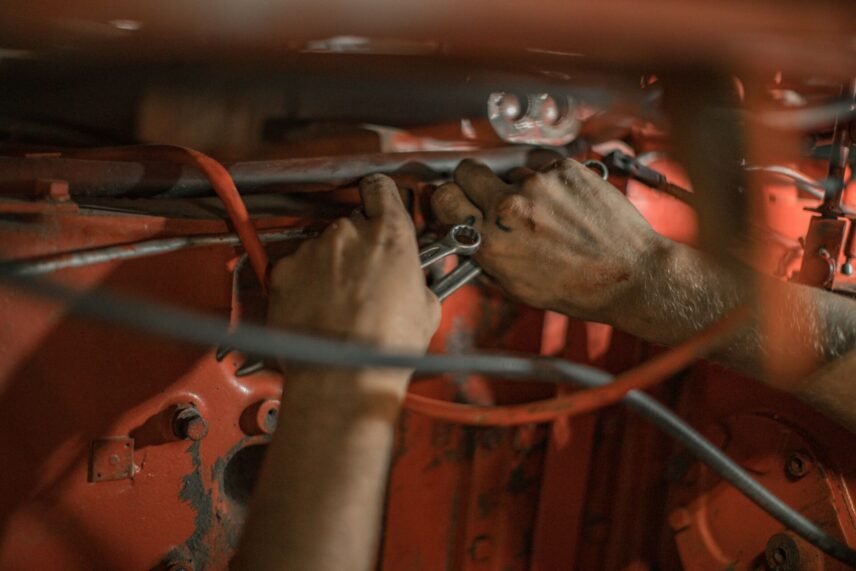 Mechanic holding tools in an auto repair workshop.