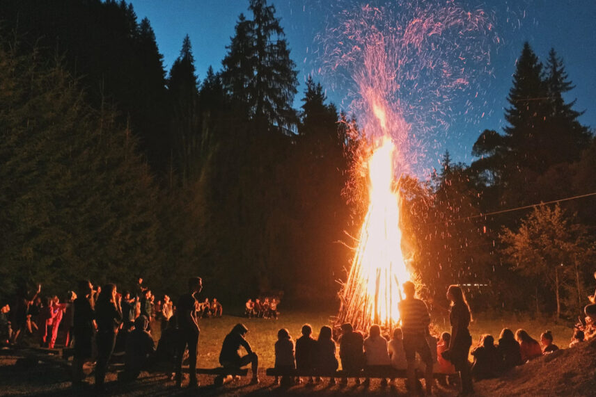 a bonfire with a crowd of people around it