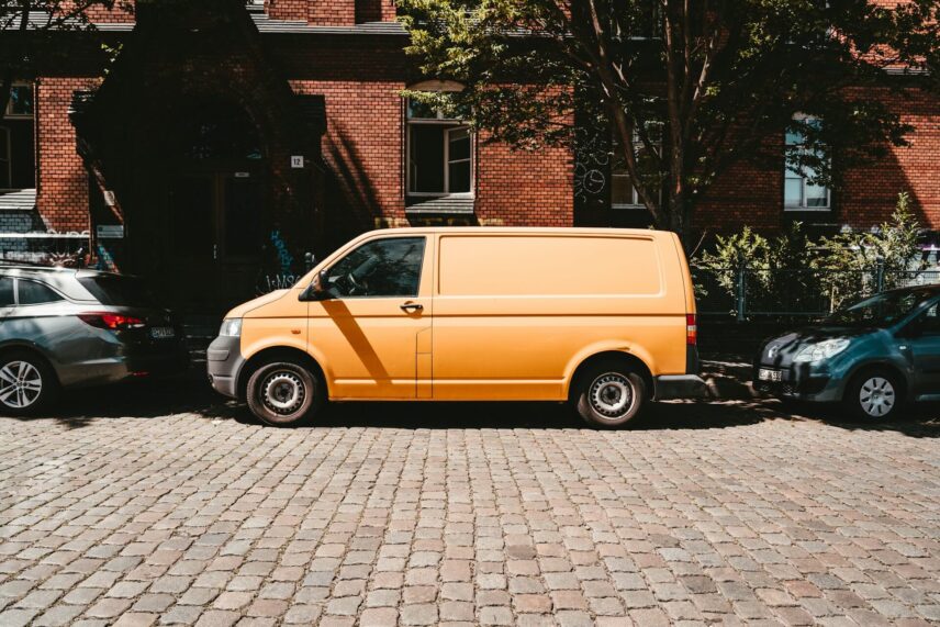 Yellow van parked beside a brown brick building