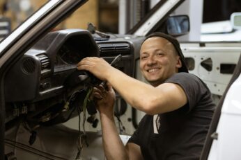 a car mechanic working on the drivers station of a vehicle