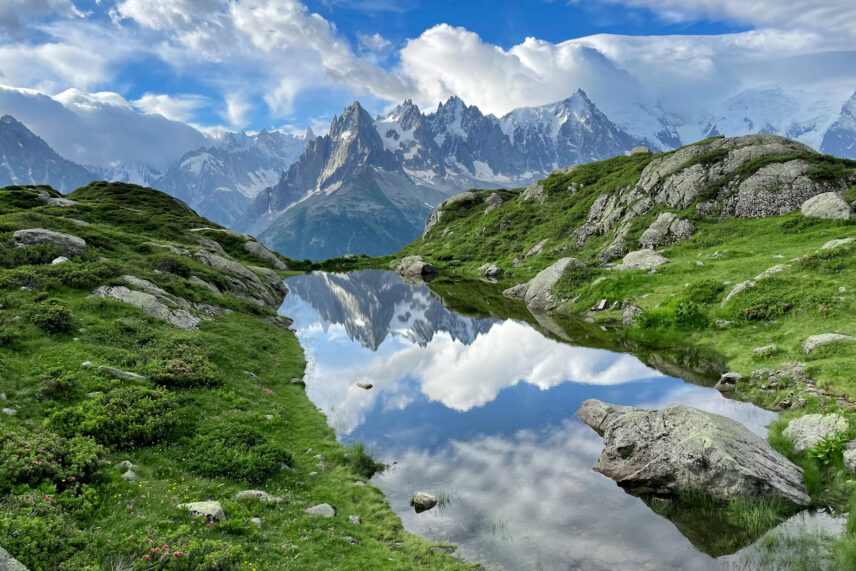 mountain steam between greenery with mountain peak in front