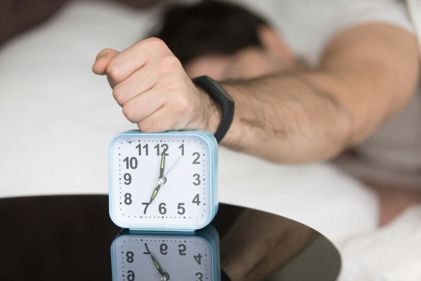 A man turning off an alarm clock